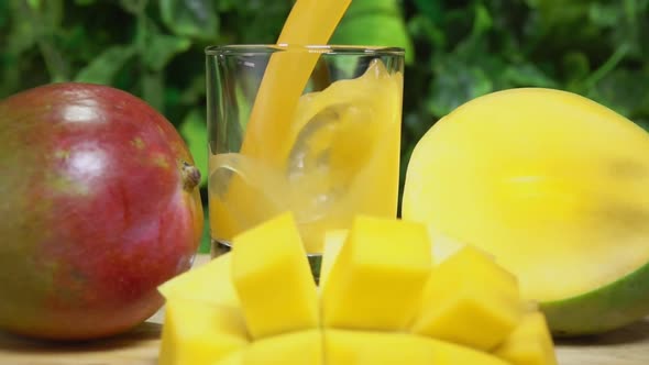 Delicious Mango Juice Is Poured in a Glass Next To Ripe Mango Cut Into Slices
