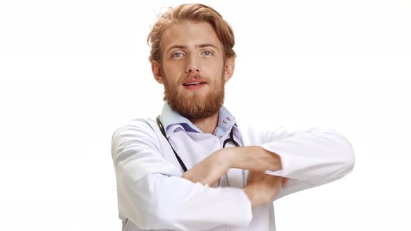 Smiling Handsome Caucasian Light Bearded Male Doctor Standing with Arms Folded on White Background