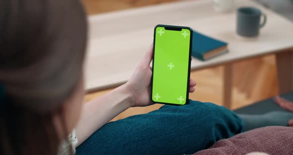 Lviv, Ukraine - January 23, 2020: Female Person Holding and Looking at Mobilephone Green Screen