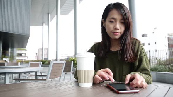 Woman use of mobile phone at outdoor cafe