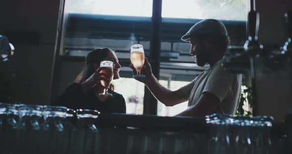 Two friends relaxing and chilling in a modern bar with a crafted beer