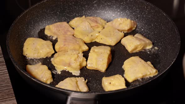 Pieces of White Fish in Dough are Fried in a Pan