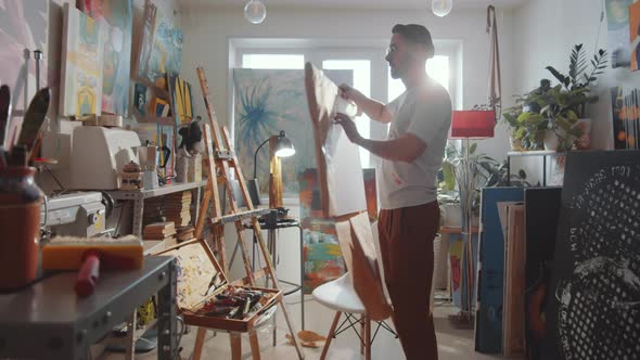 Artist Putting Blank Canvas on Easel