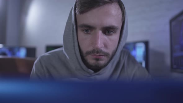 Close-up Portrait of Absorbed Nervous Programmer Checking Software on Laptop. Young Bearded