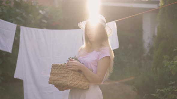 Young Charming Woman Posing in Sunrays Outdoors Holding Vegetable Basket Looking at Camera