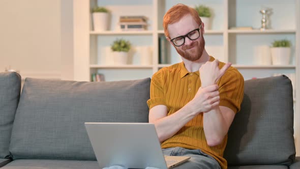 Hardworking Redhead Man with Wrist Pain Working on Laptop 