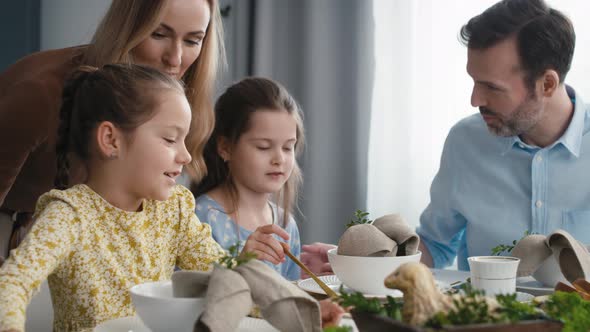 Caucasian family of five spending time over table on easter time. Shot with RED helium camera in 8K.