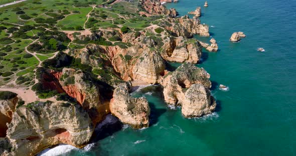Drone shot from the Algarve region in Portugal, the drone is moving closer to the coast on a sunny d