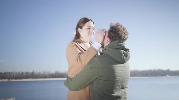 Portrait of Happy Young Chubby Woman Admiring Boyfriend and Hugging Sweetheart Outdoors. Loving