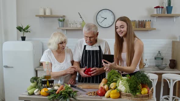 Senior Man and Woman Listening Recipe From Girl with Digital Tablet of Healthy Food Nutrition