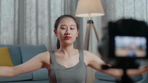 Asian Trainer Female Speaking To Camera And Doing Shoulder Cross Arm While Recording