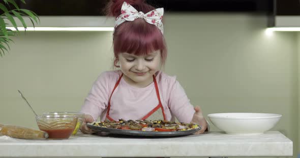 Cooking Homemade Pizza. Child Girl Stay with Raw Pizza in the Kitchen