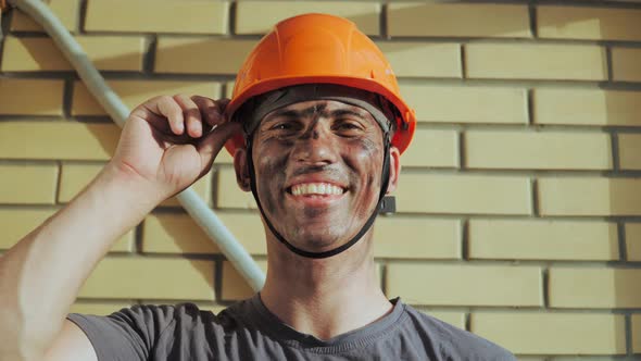 Dirty Building Worker on Background Brick Wall