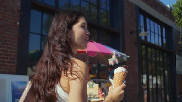 Brunette Enjoy Cold Dessert on City Stroll