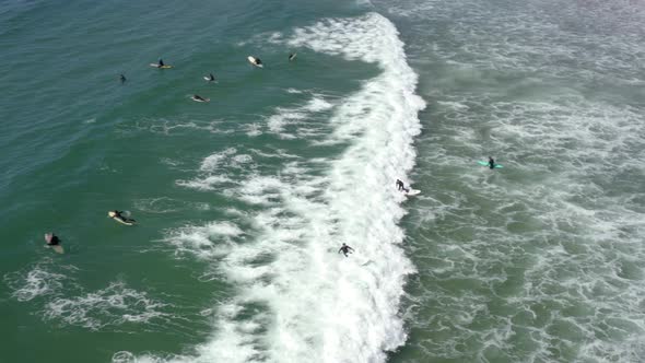 Surfer riding and turning with spray on blue ocean wave, surfing ocean. Aerial 