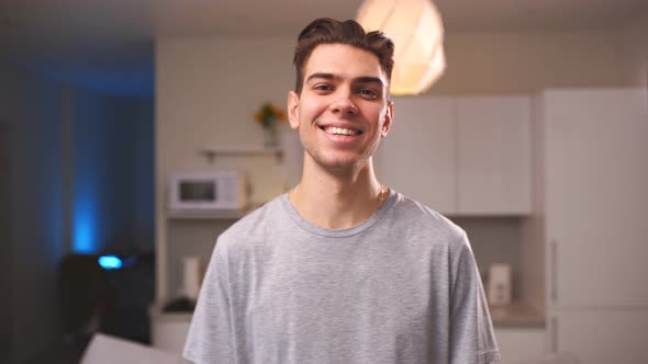 Portrait of smiling cool guy standing in living room