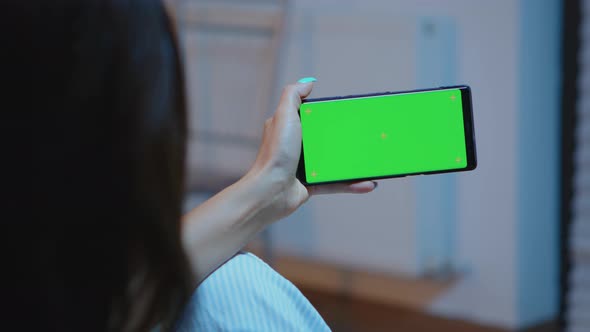 Lady Looking at Green Screen Smartphone