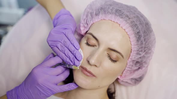 Beautiful Woman is Doing a Lip Augmentation Procedure in a Beauty Salon