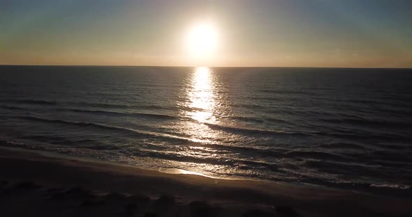 Aerial drone shot of the beach at sunset on Captiva Island, Florida. Slow wide pan to the left.