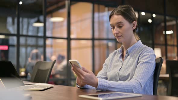 Young Woman Using Smartphone at Work