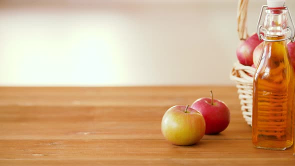 Apples in Basket and Bottles of Juice on Table