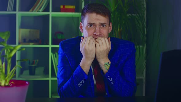 Nervous Businessman Bites His Nails Sitting in Office