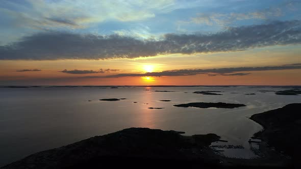 Aerial beautiful sunset with vivid and cinematic colours at a rocky coastline with islands.