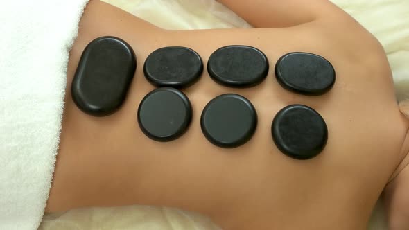 Therapist Putting Hot Stones on Clients Back