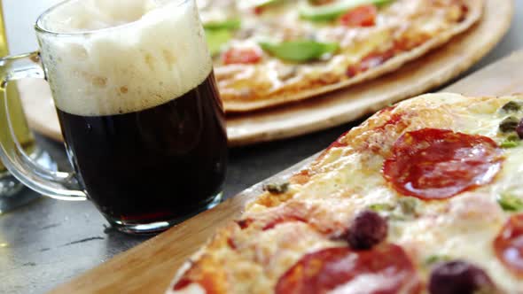 Delicious pizza with glasses of beer and soft drink