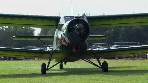 Close-up view of an Antonov An-2 biplane at a small airfield.