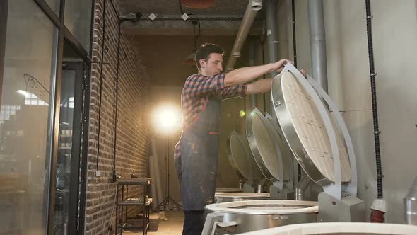 Caucasian Man Closing Oven For Firing Ceramics Pots