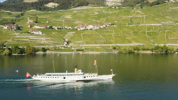 Aerial panning following CGN Belle-Epoque steam boat on Lake Léman in front of Lavaux vineyard.Cull
