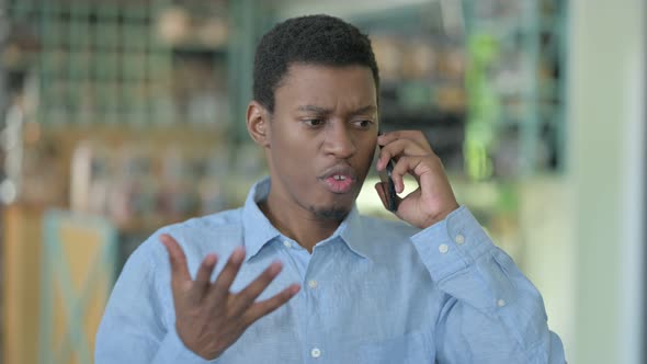 Angry Young African Man Arguing on Smartphone 