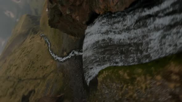 Drone Shot Down a Waterfall Along the Mountain Dew Towards to Beautiful Valley