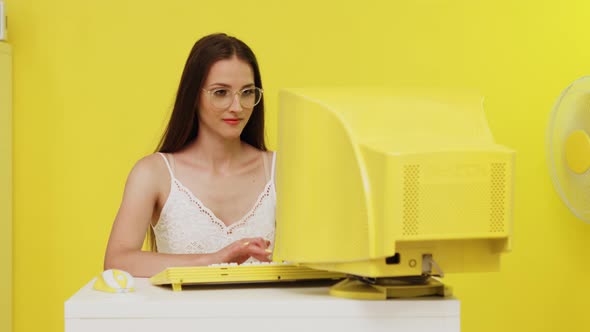 Woman Is Typing at Yellow Retro PC
