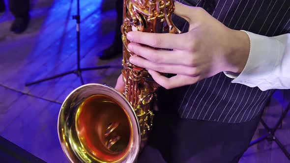 The Hands of a Teenager Playing on a Saxophone