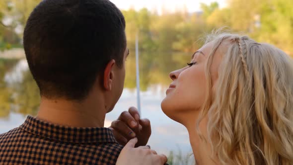 lovely young couple fishing together by a lake, river fooling and smile shot from behind