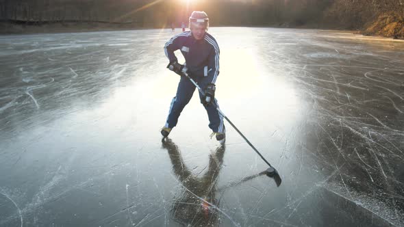 MOSCOW RUSSIA 10 DECEMBER 2019 Hockey Player on Frozen Lake Make Ice Sparkles on High Speed Braking