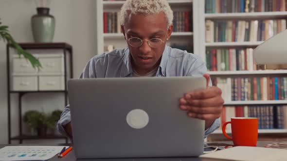 Confident African Man Using Laptop Sitting at His Home Desk