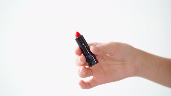 Female Hands Holding Lipstick Against White Background