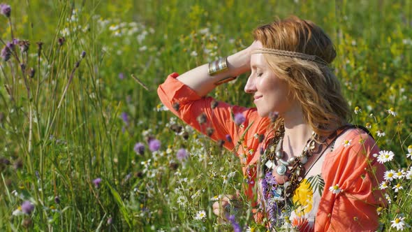 Portrait of Blonde Hippie Dancing in a Field with Flowers