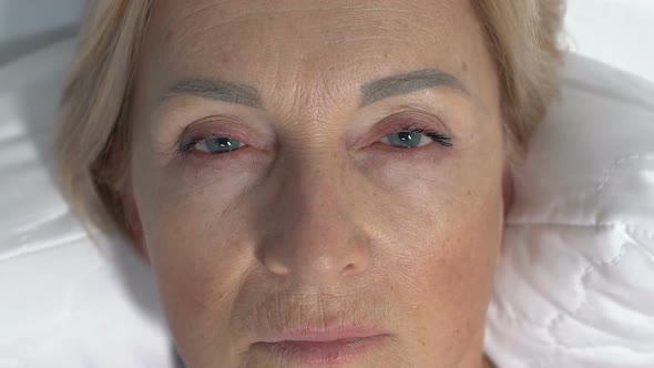 Face of Depressed Senior Woman Awakening in Morning and Looking at Camera