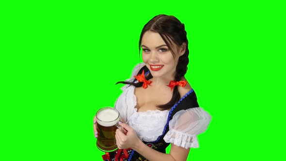 Girl in Bavarian Costume Offers a Glass of Beer. Green Screen