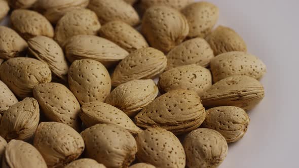 Cinematic, rotating shot of almonds on a white surface - ALMONDS