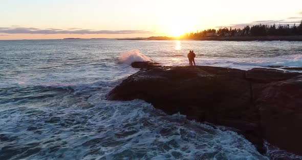 Couple kissing by the shore while watching the sunset