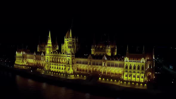 Aerial Drone View of Parliament Building in Budapest is Lit By Lanterns at Night