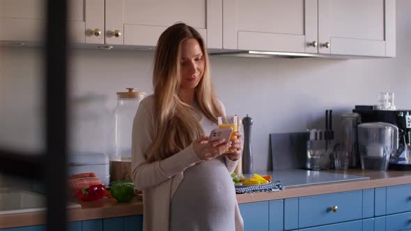 Pregnant woman drinking healthy juice and using mobile phone. Shot with RED helium camera in 8K