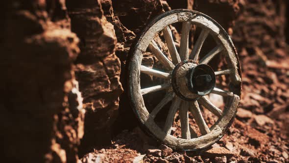 Old Wooden Cart Wheel on Stone Rocks