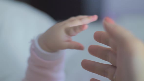 Baby's Tiny Fingers Holding Mother's Hand