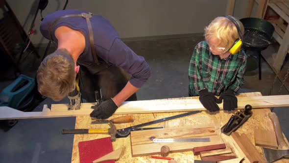 Slow Motion, Boy Helps Man in Apron in the Workshop